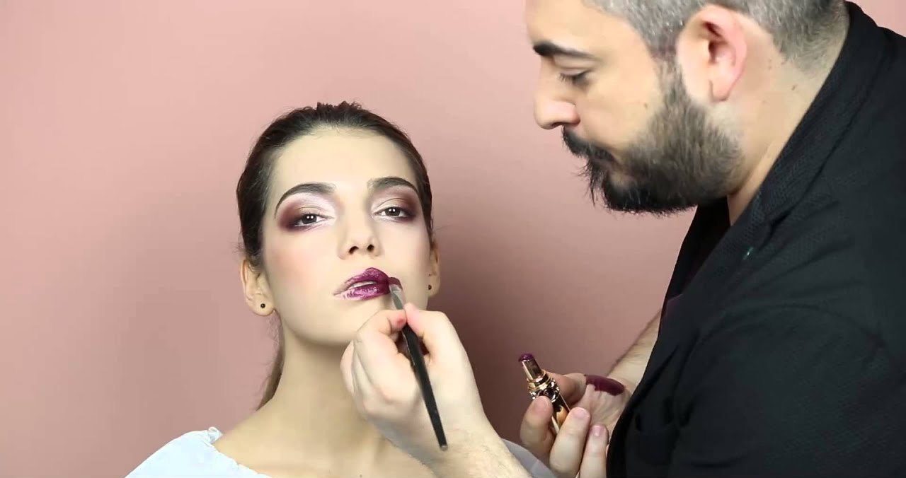 Antonio Lagani applica un rossetto prugna a una modella durante un tutorial